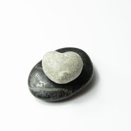grey heart on black stoneの写真素材