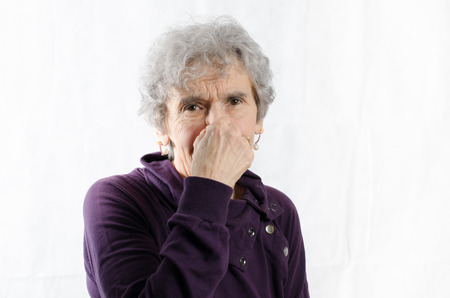 old woman is holding her noseの写真素材