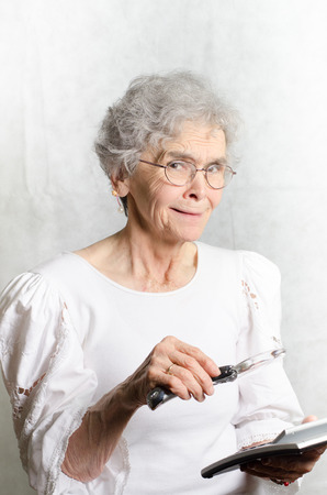 old woman with calculator and magnifying glassの写真素材