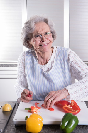 active senior preparing paprika in kitchenの写真素材