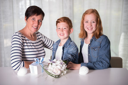Happy family celebrating birthday with presents and flowers