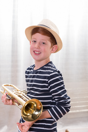 Portrait young boy with trumpet smiling into cameraの写真素材