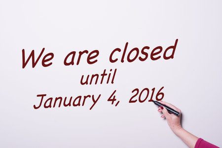 woman's hand with pen on whiteboard writing we are closed