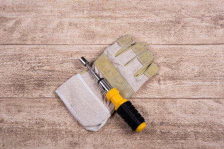 steel tool and working glove on a wooden table