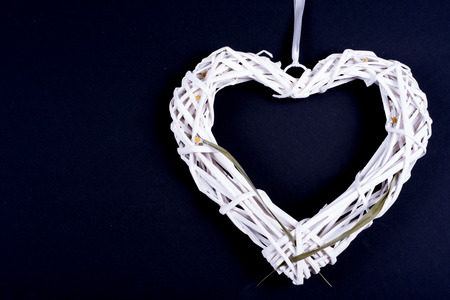 white heart from wickerwork with grass on black backgroundの写真素材