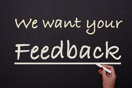 woman is writing on blackboard we want your feebackの写真素材