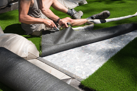 professional gardener is cutting artificial turf to fitの写真素材