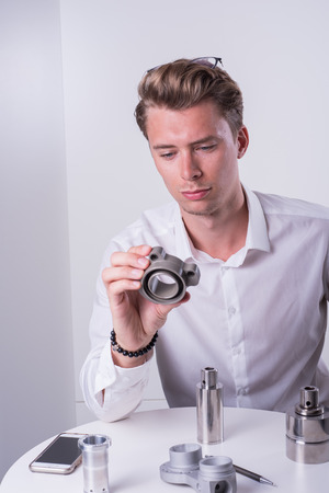 young engineer is inspecting machine spare partsの写真素材