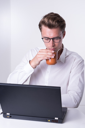 young business man having a coffee while working with laptopの写真素材
