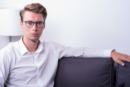 young handsome man relaxing at home on the couchの写真素材