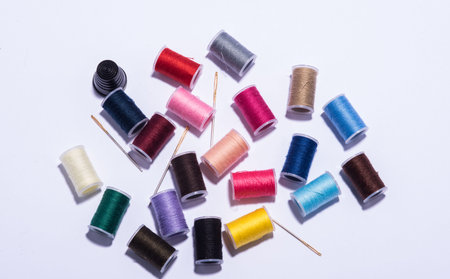 colorfull plastic yarn spools on white background