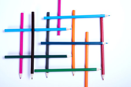 colorful pencils organized in a geometric form on white background