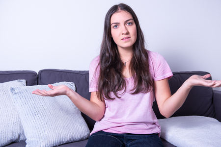 Portrait of a young beautiful woman arguing and gesturingの写真素材