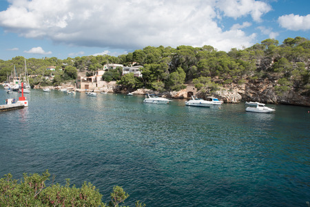 Rocky cove on Mallorca with ships in the sunの写真素材