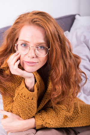 Portrait of beautiful, red-haired woman with orange sweaterの写真素材
