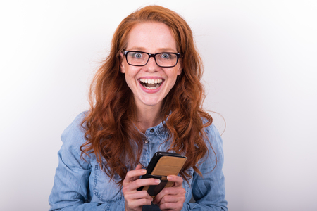 attractive young woman likes what she sees on the smartphoneの写真素材