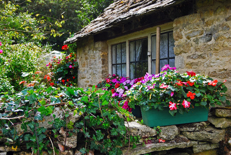 Stone wall with flowers of rural cottage in Cotswolds, Englandの写真素材