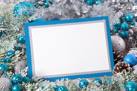 Blank Christmas card with blue envelope surrounded by decorations. Space for copy.の写真素材