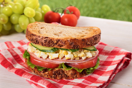 Ham and egg picnic sandwich on summer outdoor tableの写真素材