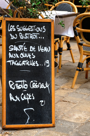 Menu board with tables and charis at French restaurant の写真素材