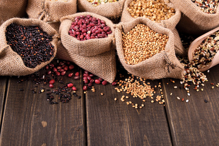 Various grains and cereals in sack on wooden backgroundの写真素材