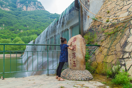 Girl with rock tablet by the river damのeditorial素材