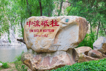 Rock monument with Chinese characters by the water streamのeditorial素材
