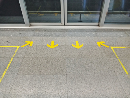 In and Out arrow sign for queue at train station