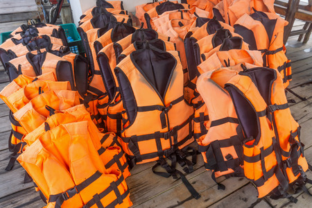 Group of orange life jacket on boat floorの写真素材