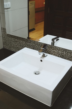 Bright space - a silver tap in a white bathroomの写真素材