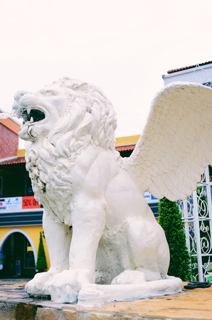 A lion statue sits on it's pedestalの写真素材