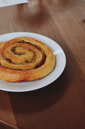 cinnamon rolls and nuts on a wooden breakfast tableの写真素材