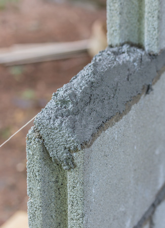 Brick laying, bricklaying spreading a bed joint  Bricklaying foundation walls, spread a mortar bed joint for building brick の写真素材