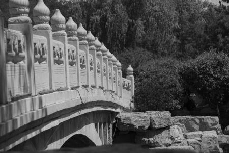 The railings of the finely carved white marble eight-hole stone bridge on the pond in the Chinese gardenの写真素材