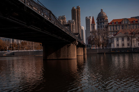 Early winter scenery along the city river and the old iron bridge