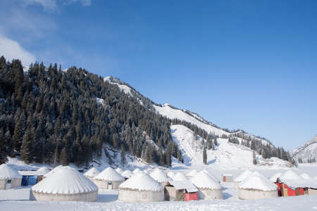 Snow scene in the mountains with white yurts