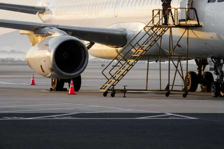 The plane in front of the airport terminal at sunrise