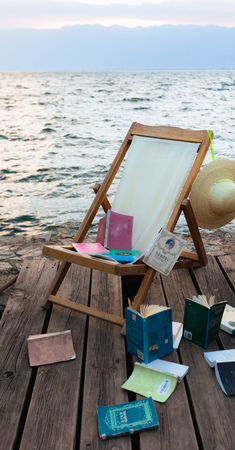 Lounge chairs on the beach and scattered booksのeditorial素材