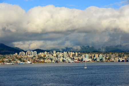 North Vancouver city skyline across Vancouver Harbour in a cloudy day, Vancouver, British Columbia, Canada.の写真素材