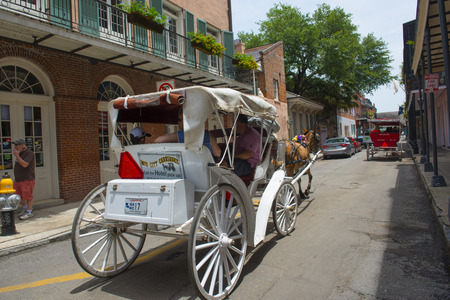 Horse drawn carriage tours on Chartres Street between Dumaine Street and St Ann Street in French Quarter in New Orleans, Louisiana, USA.のeditorial素材