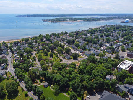 Aerial view of historic residence building and coast with Salem in the background in historic city...