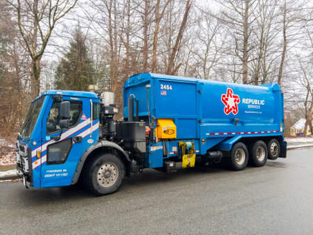 Republic Services garbage truck collect trash and recycle dust bins in suburban community in Massachusetts MA, USA.のeditorial素材