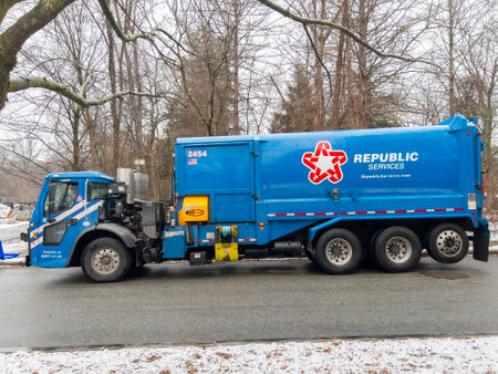 Republic Services garbage truck collect trash and recycle dust bins in suburban community in Massachusetts MA, USA.のeditorial素材