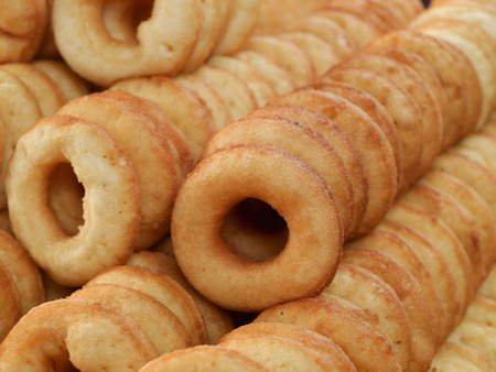 A photo a group of high-calorie fried ring doughnuts Thai style toped with white sugar. Diet and rejection of flour products concept.の写真素材