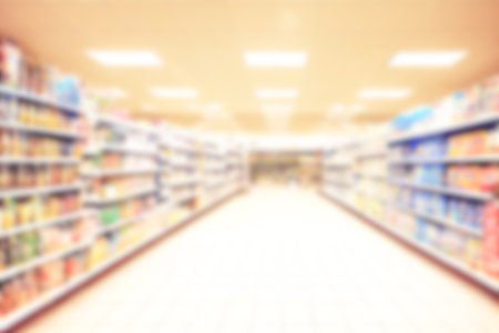 Abstract blurred background supermarket aisles with colorful shelves of merchandise. Perspective view of supermarket aisle with copy space in center, can use as background or retail conceptの写真素材