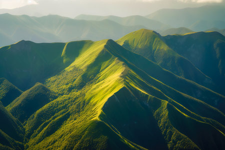 Beautiful sunrise over the green mountains in morning light with fluffy clouds on a bright blue sky. Nature freshness concept.の写真素材