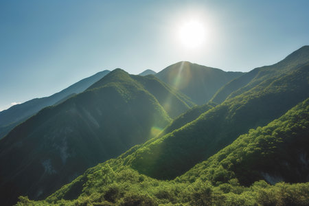 Beautiful sunrise over the green mountains in morning light with fluffy clouds on a bright blue sky. Nature freshness concept.の写真素材