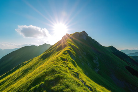 Beautiful sunrise over the green mountains in morning light with fluffy clouds on a bright blue sky. Nature freshness concept.の写真素材