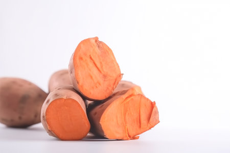 Close up of sweet potatoes on white background with copy space. Healthy vegan vegetarian food concept.の写真素材