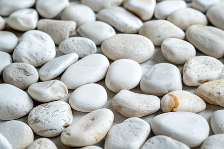 Close-up of white rounded river stones creating a serene and textured background.の素材